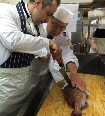 Chef Piero killing a fish under the guidance of head chef Matsuura