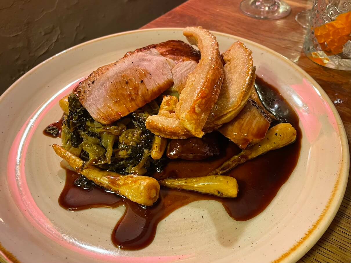 Tamworth pork loin, with pig cheek, rarebit-topped potato cake, parsnips, Savoy cabbage and ginger ale jus at the Kings Head Inn Bledington