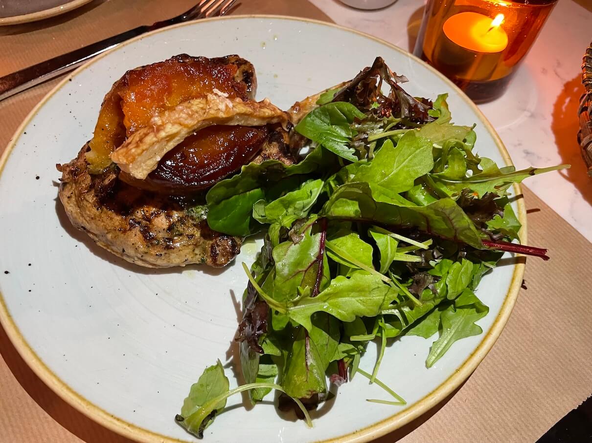 The main of grilled pork chop with caramelised apple and herb butter